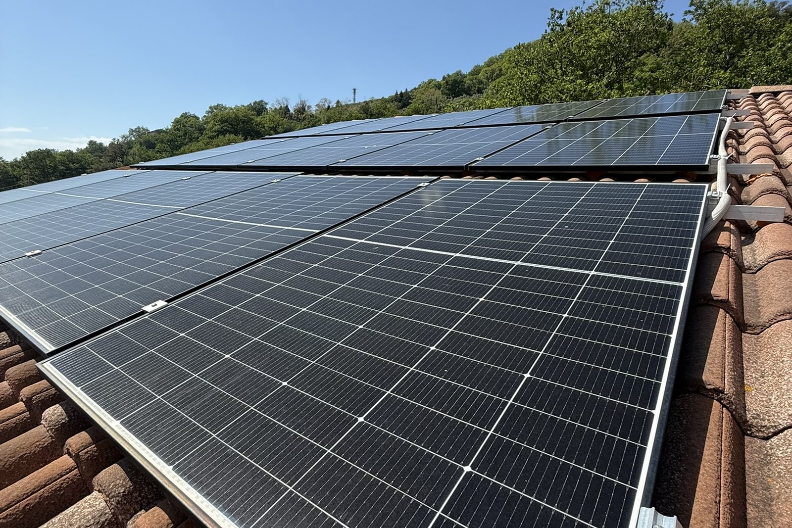 Ganci di ancoraggio dei moduli fotovoltaici su un tetto a falda con coppi